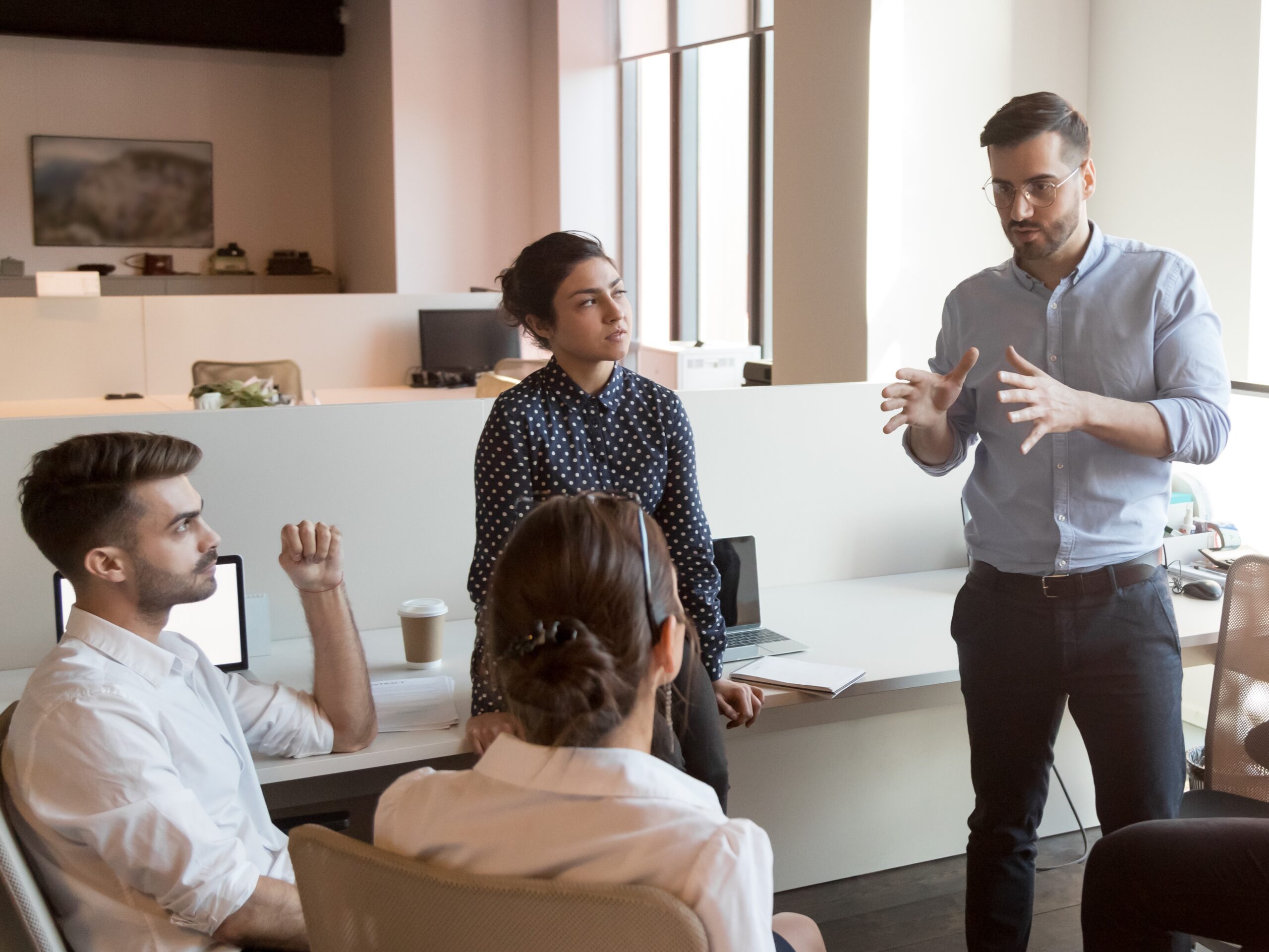 Serious team leader talk to diverse business people at meeting